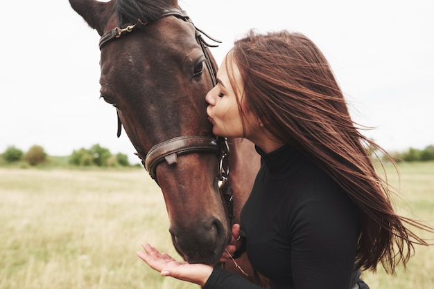 Een gelukkige vrouw communiceert met haar favoriete paard. de vrouw houdt van dieren en paardrijden