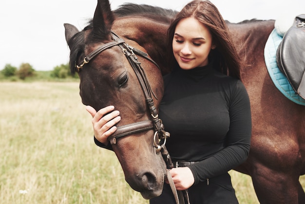 Een gelukkige vrouw communiceert met haar favoriete paard. De vrouw houdt van dieren en paardrijden