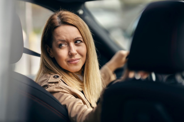 Foto een gelukkige vrouw gaat achteruit met haar auto