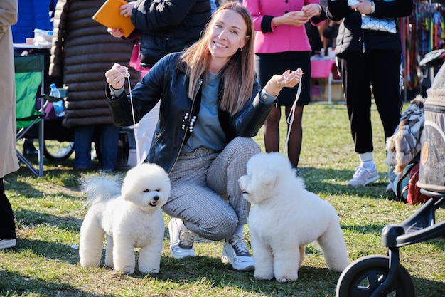 Een gelukkige vrouw met twee geliefde honden van het ras Bichon Frise