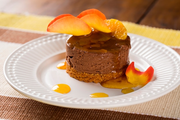 Een gerecht van chocolademousse met mandarijnsiroop boven de tafel.