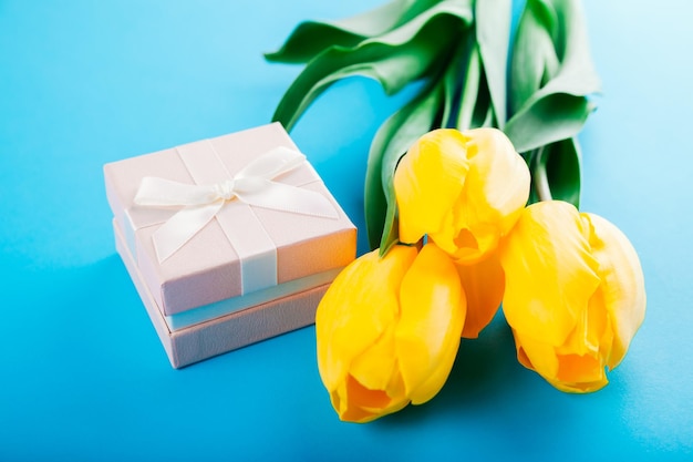 Een geschenkdoos met tulpen op blauwe achtergrond