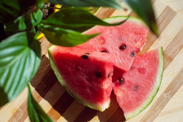 Een gesneden rijpe watermeloen ligt op een houten tafel