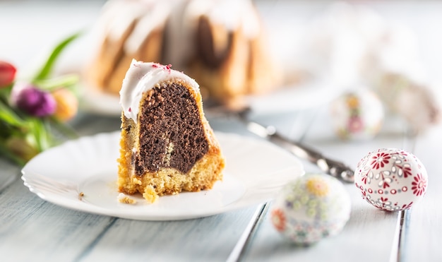 Een gesneden stuk marmeren paascake op een witte plaat.