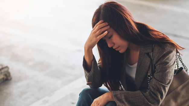 Een gestresste jonge Aziatische vrouw die alleen zit