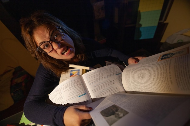 Een gestresste vrouw studeert in een bibliotheek voor haar eindexamen