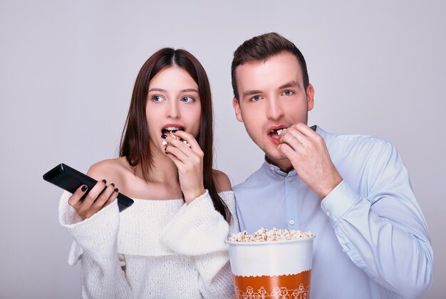 Een getrouwd stel liefhebbers dat gezouten popcorn eet tijdens het kijken naar een film