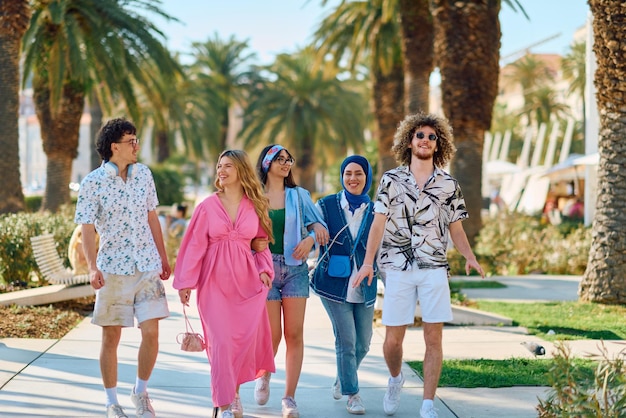 Foto een gevarieerde groep toeristen gekleed in zomerkleding wandelt door de toeristische stad met brede