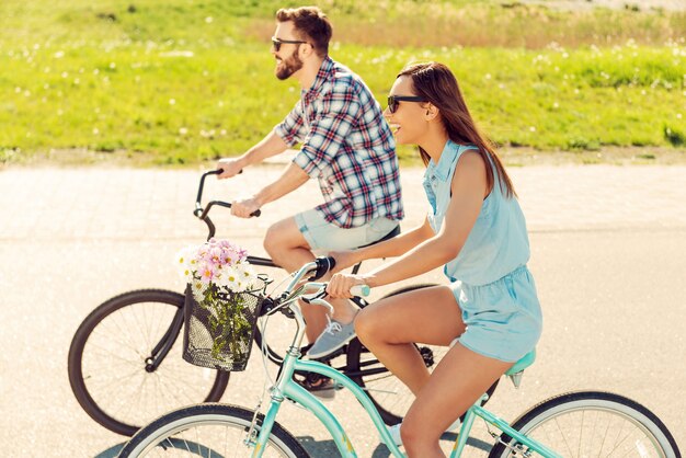 Een geweldige tijd samen hebben. Vrolijk jong stel samen fietsen en glimlachen