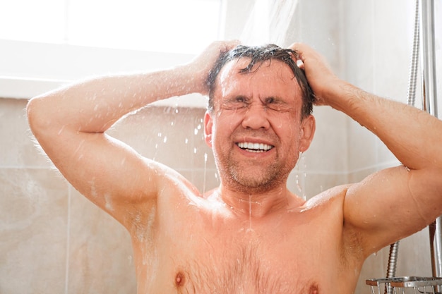 Foto een gewone man wast zijn haar in een doucheclose-up