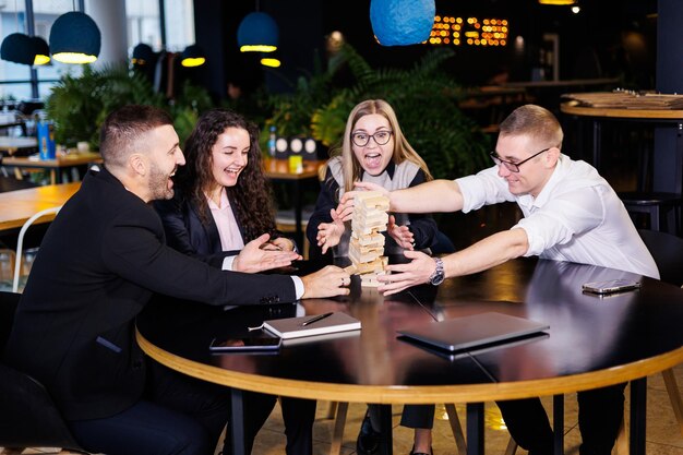 Een gezelschap van collega's op kantoor speelt tijdens een pauze het bordspel jenga leuke bordspellen voor vrienden