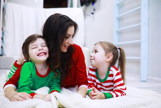 Een gezin in gestreepte pyjama's rust thuis Kleine kinderen verkleed als elfjes liggen op de bank Gelukkig gezin
