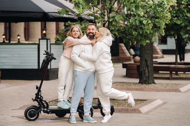 Een gezin in witte kleren staat in de stad op elektrische scooters.