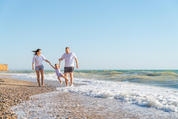 Een gezin loopt langs het strand in de oceaan.
