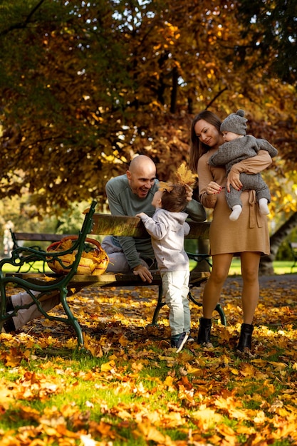 Een gezin met twee kinderen op een wandeling in het park in de gouden herfst