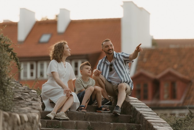 Een gezin ontspant op de trap tussen daken in een oude Europese stad