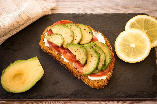 Een gezond en diëtisch broodje met kaas, salami en avocado - gezond en smaakvol eten - volkoren brood met pitjes