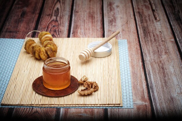 Een gezond ontbijt met een noot van walnoot en fruit en biologische honing op de houten tafel achtergrond.