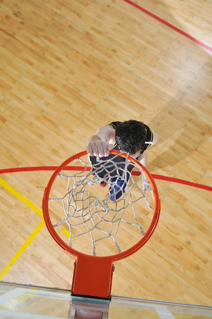Een gezonde jonge man speelt basketbal in de school.