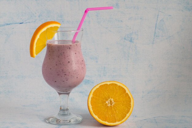 Een glaasje aardbeiensmoothie met een schijfje sinaasappel