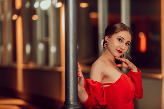 Een glamoureuze vrouw in een rode jurk poseert in de stad