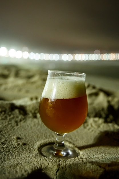 Een glas bier op het strand van Copacabana in Rio de Janeiro, Brazilië. Nachtverlichting.