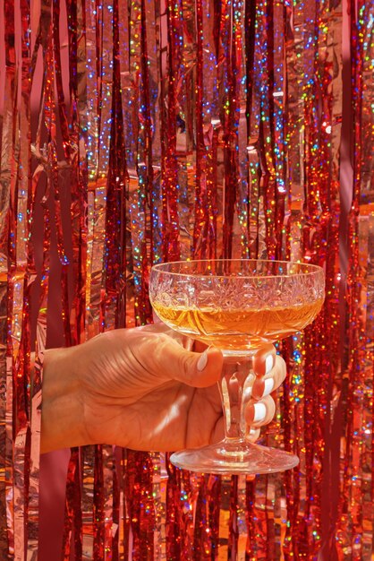 Een glas champagne in de hand van een vrouw op de achtergrond van een feestelijke nieuwjaarsfeestachtergrond