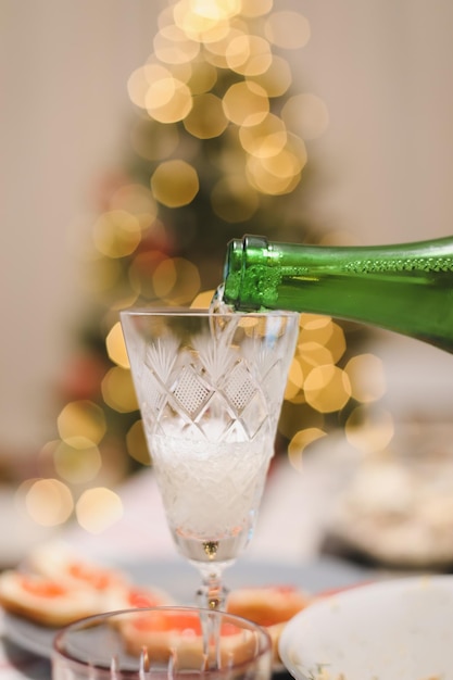 Een glas champagne op een tafel tegen de kerstboom