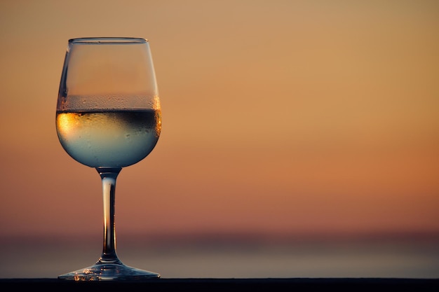 Een glas chardonnay bij zonsondergang.