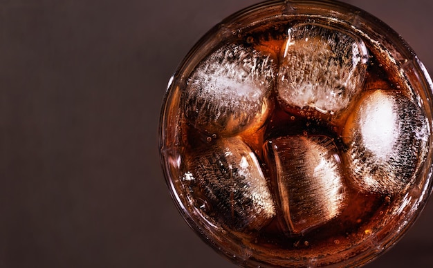 Een glas cola drinken met ijsblokjes bovenaanzicht Verse koude zoete cola drinken met ijs