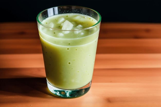 Een glas groene smoothie staat op een houten tafel.