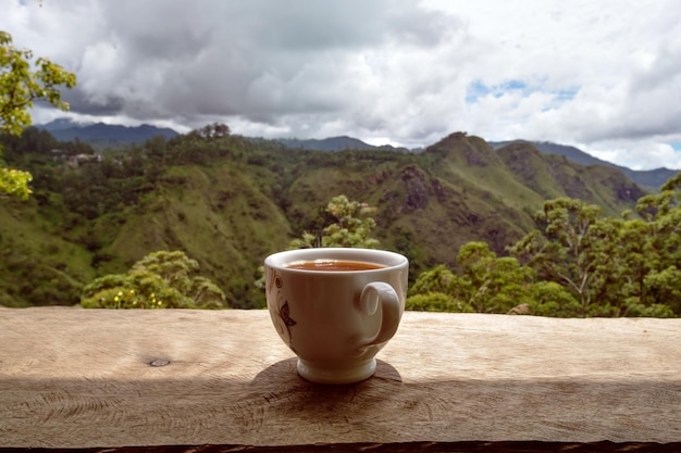 Een glas hete thee op tafel in theewinkel en uitzicht op Small dams Peak in Sri Lanka