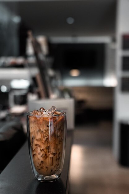 Een glas ijskoffie met melk op tafel.