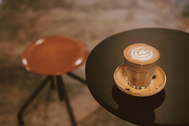 Een glas koffie latte art op tafel.