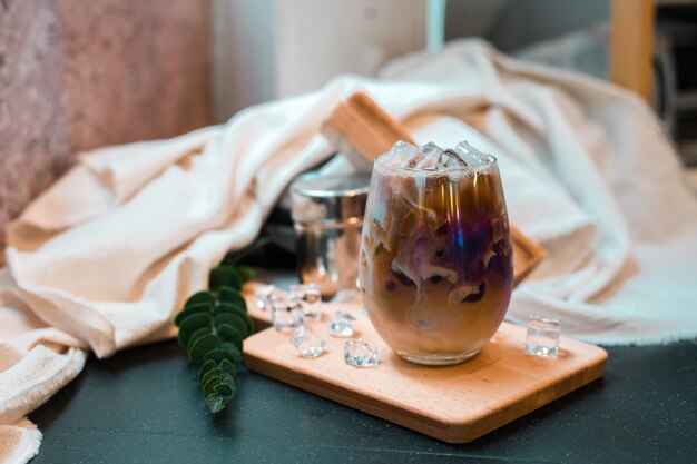 Een glas koffie met melk op de tafel.