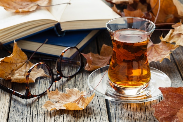 Een glas kopje thee in de herfst omgeving