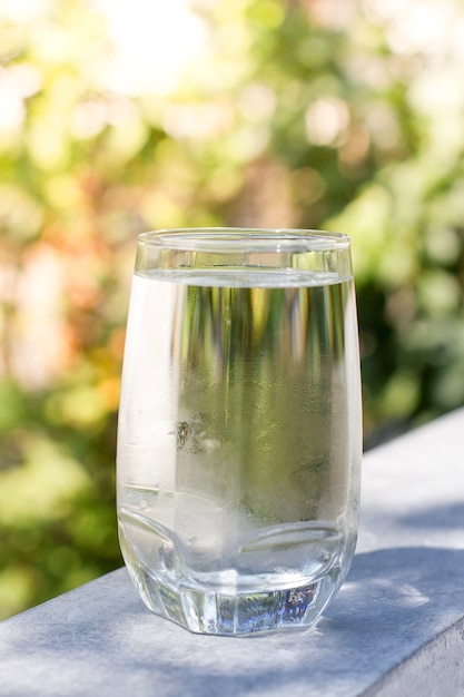 Foto een glas koud water op de achtergrond van de natuur voor verfrissend