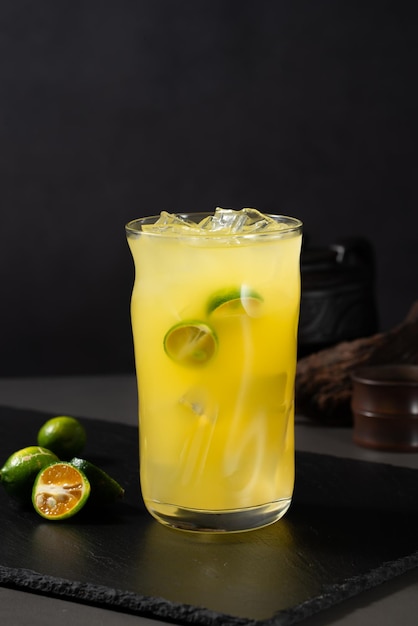 Een glas mango limonade met een schijfje limoen op de rand.