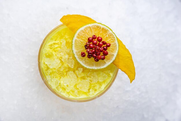 Een glas mango-smoothie met een schijfje mango er bovenop