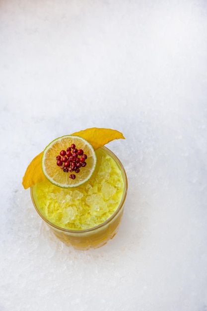 Een glas mangosap met daarop een schijfje fruit