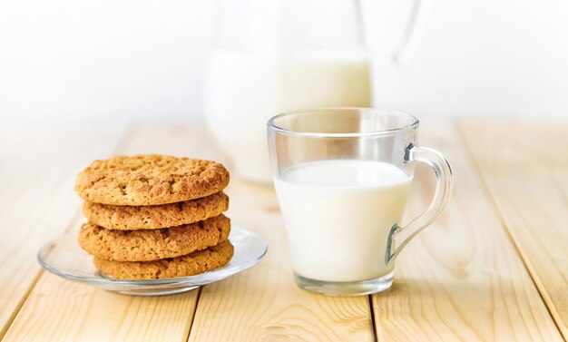 Een glas melk met koekjes op een houten tafel