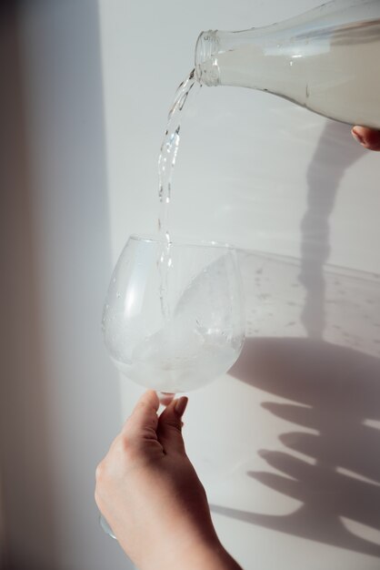 Een glas met ijs en een fles water