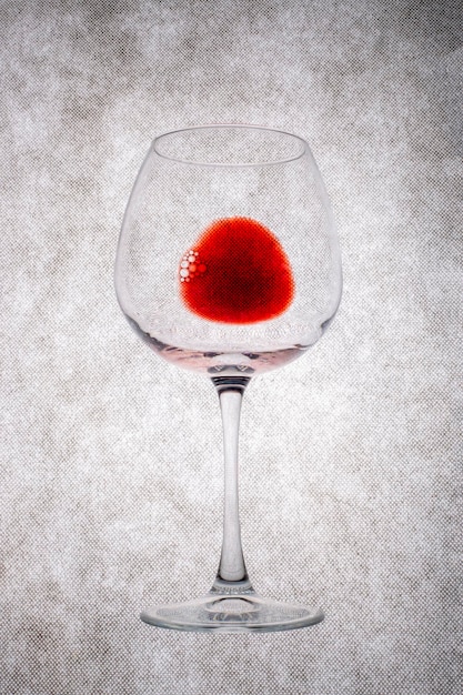 Een glas rode wijn op een grijze achtergrond