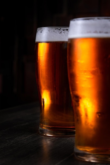 Foto een glas schuimend bier op een donkere achtergrond