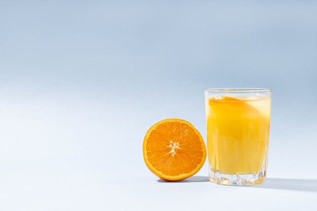 Een glas sinaasappelsap en een half gesneden sinaasappel