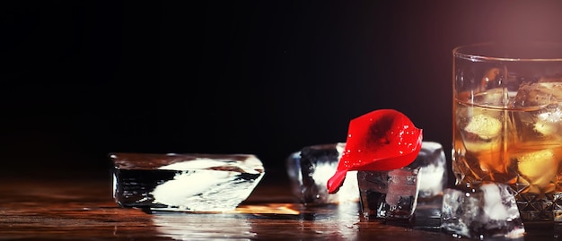 Een glas sterke alcoholische drank met ijs op een houten toog whisky met ijsblokjes glas met een gekoeld drankje