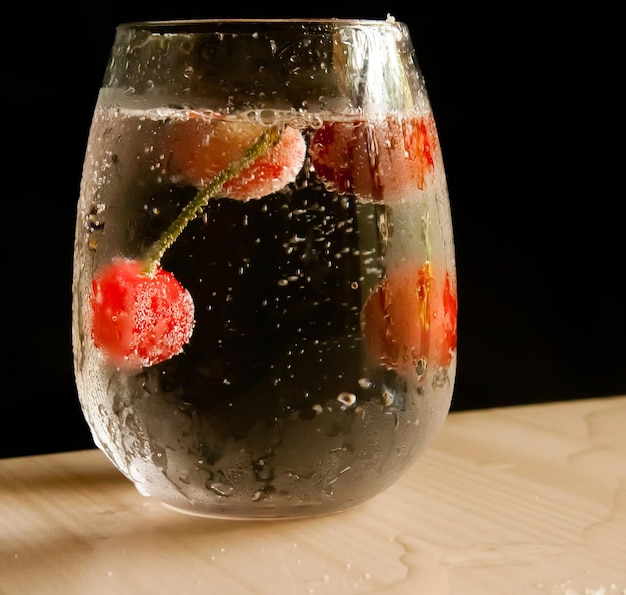 Een glas water met een vrucht erin en een glas met een vloeistof erin.