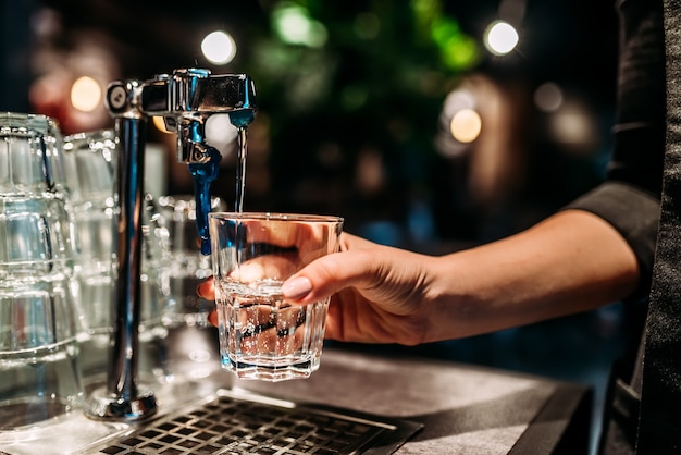 Een glas water uit een kraan gieten.