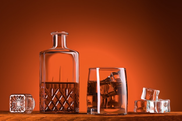 Foto een glas whisky of cognac, een karaf en ijsblokjes