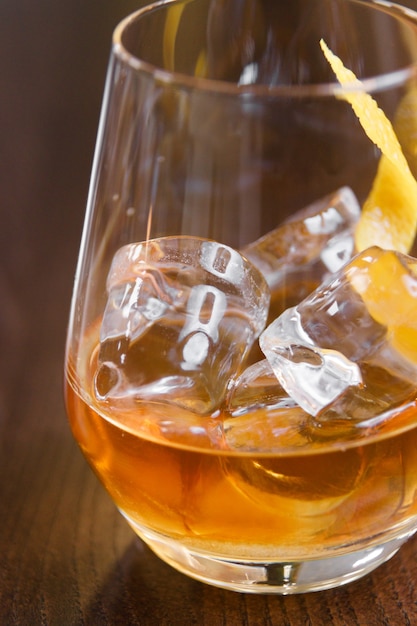 Een glas whisky op de rotsen op de bar. Een glas sterke alcohol close - up in macro.